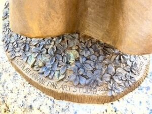 violets at the feet of Saint Frances Xavier Cabrini bronze sculpture in Chicago